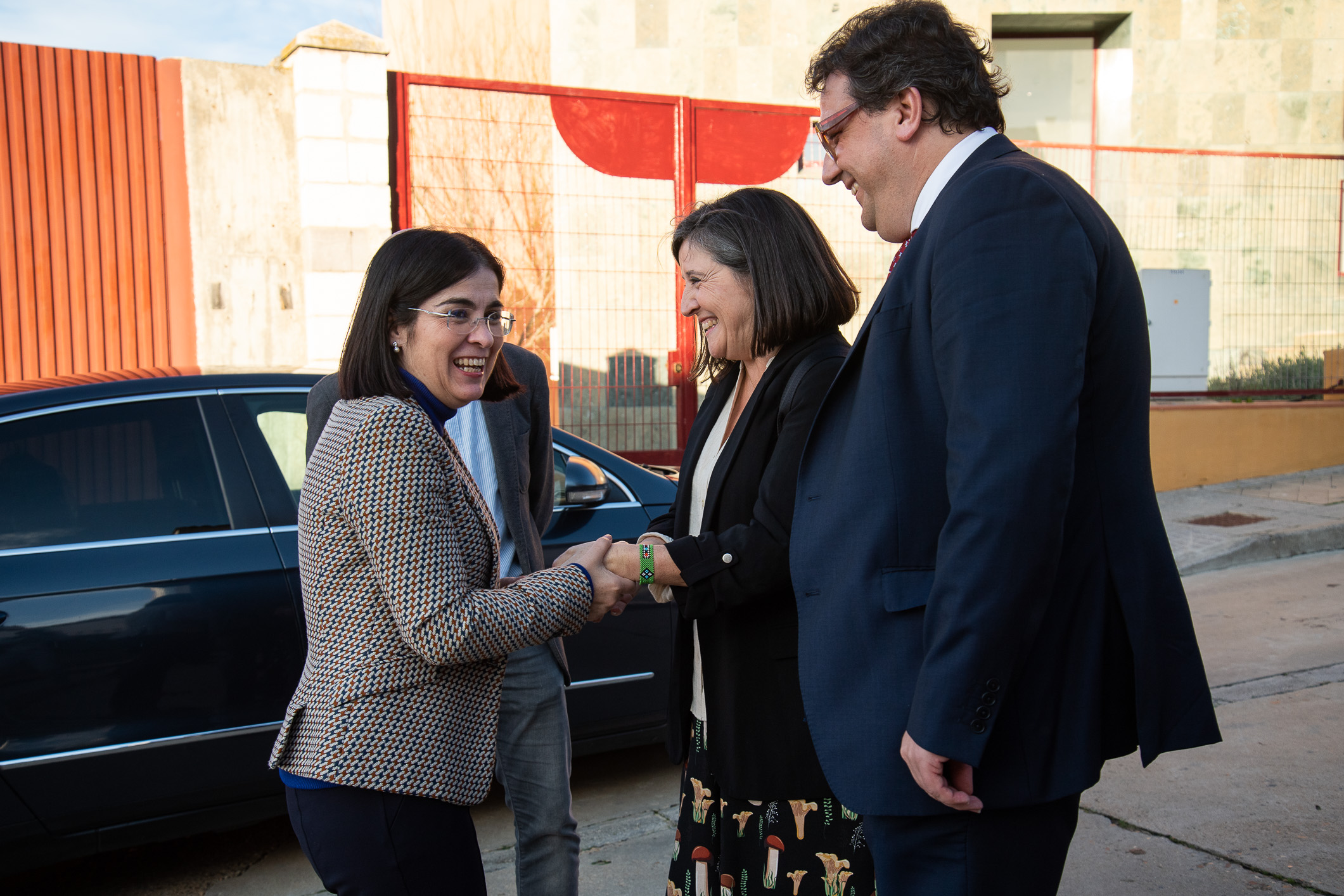 Foto de la ministra de Sanidad, junto al consejero de Sanidad, saludando a la enfermera que recibe la medalla