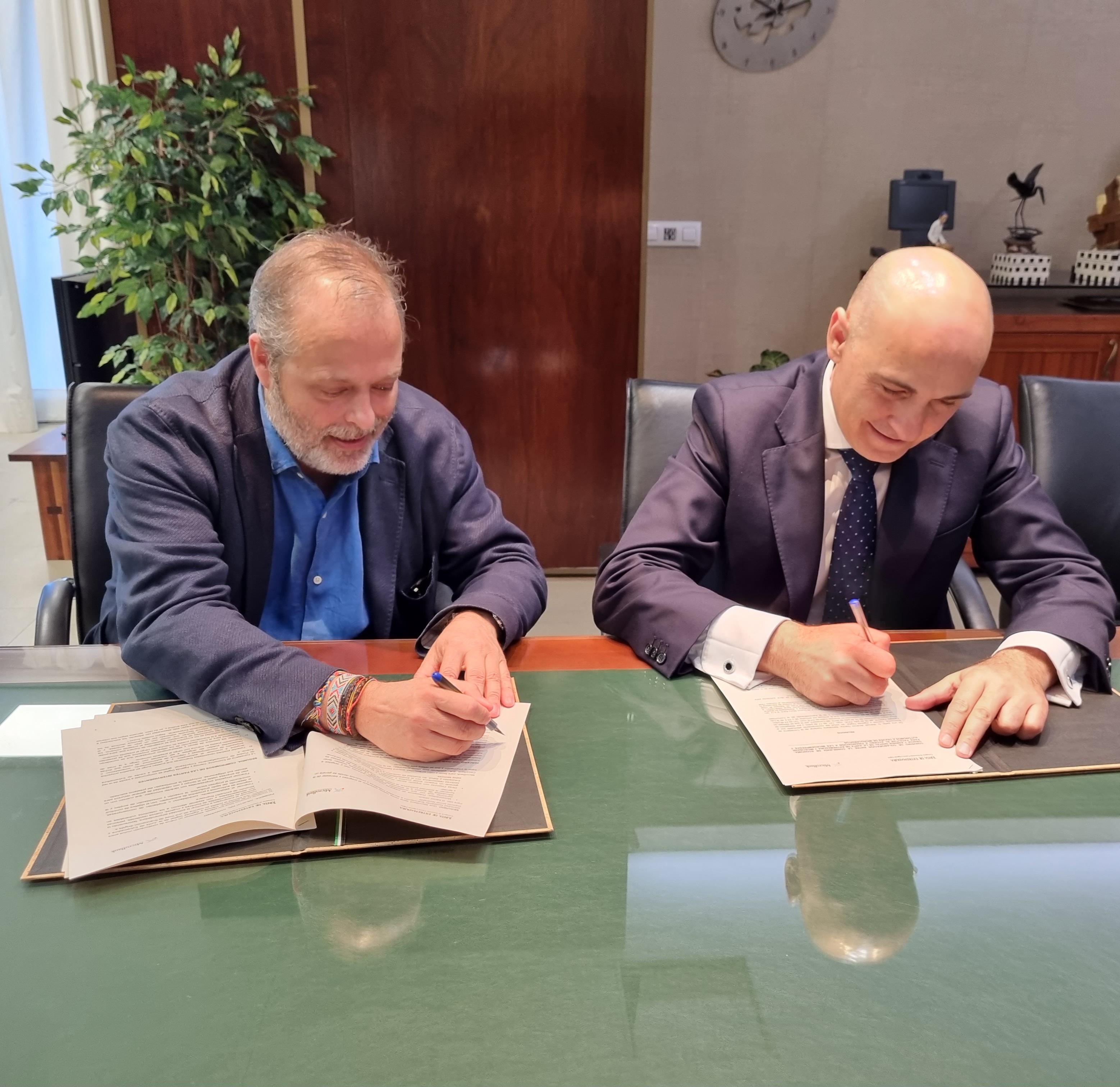 Foto del consejero de Economía, Ciencia y Agenda Digital y el director territorial de CaixaBank en Castilla-La Mancha y Extremadura firmando el acuerdo