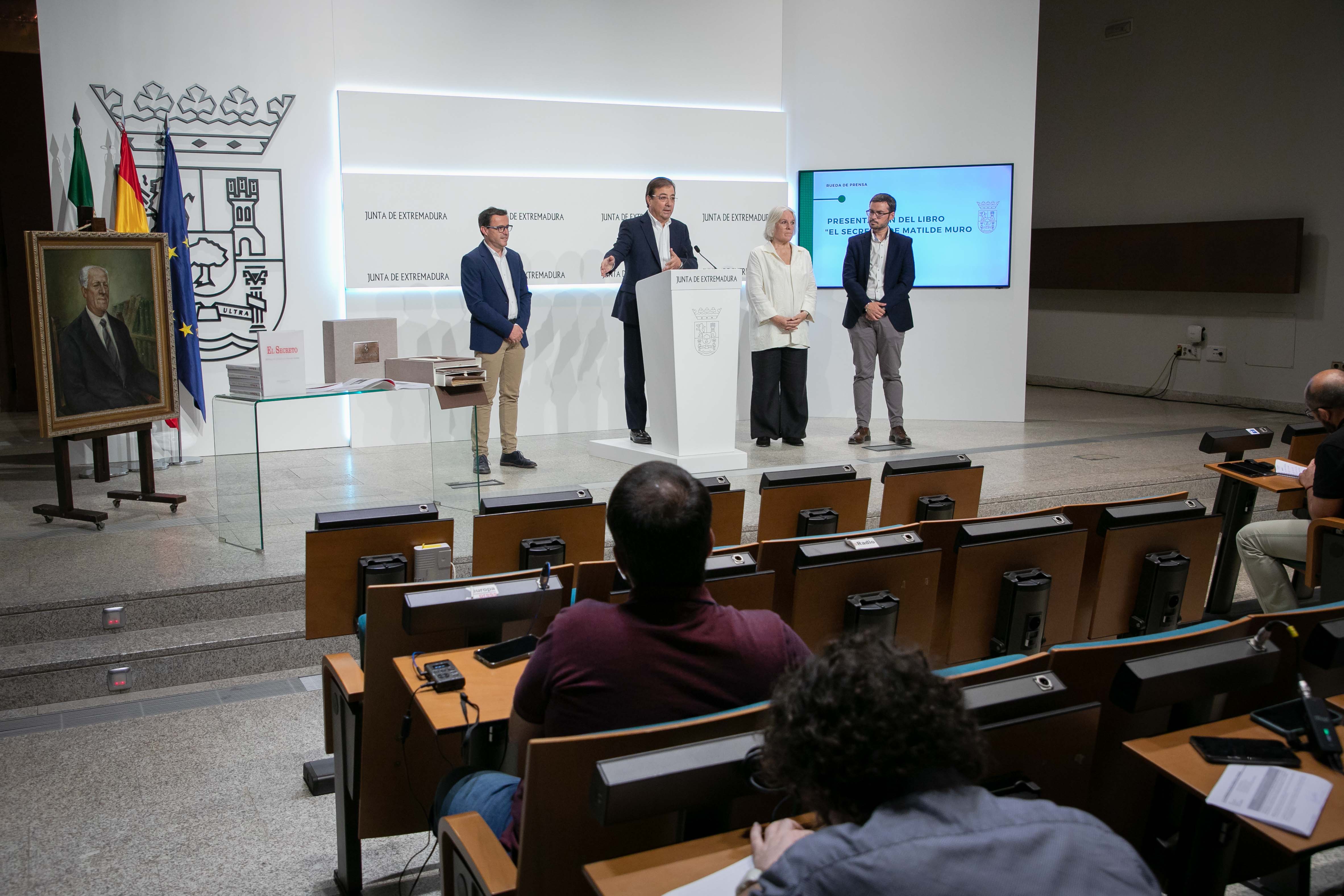 Foto del presidente en funciones de la Junta de Extremadura y la autora del libro, entre otros, durante la presención