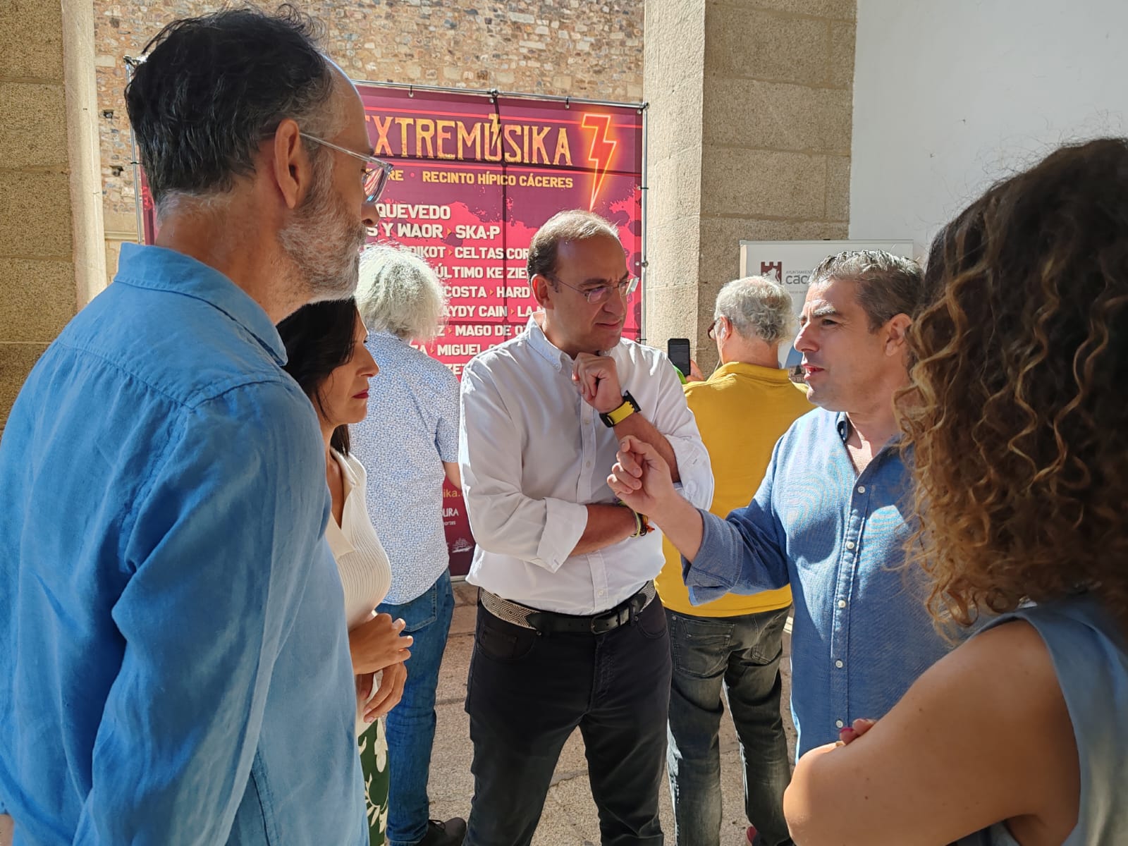Foto del secretario general de Cultura (de espaldas) conversando con el promotor del festival y otras autoridades