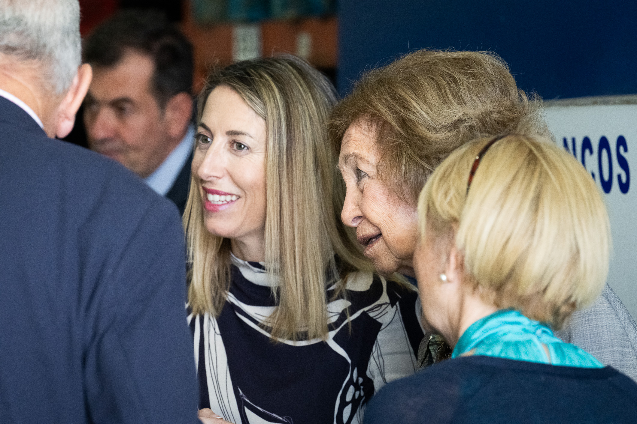 María Guardiola y Doña Sofía escuchan a un voluntario